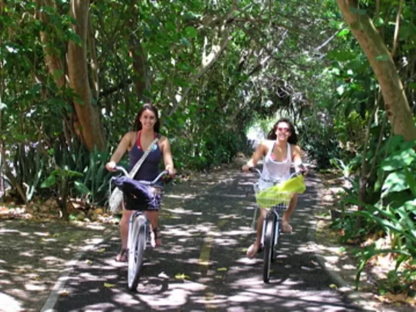 Two girls biking around Waimea Bay area