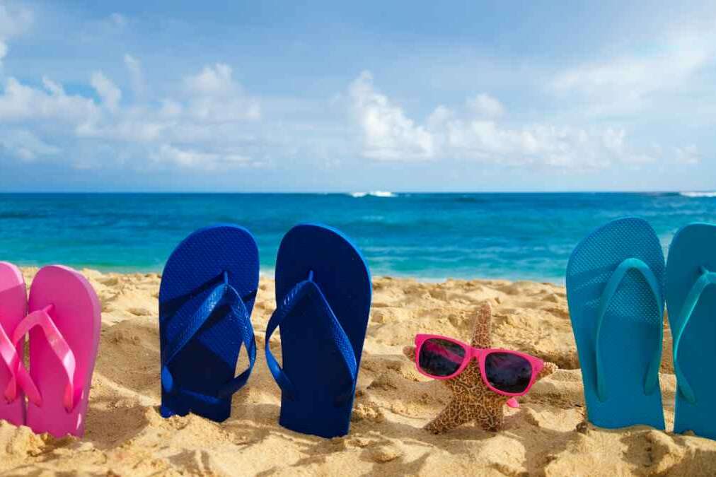 Flip flops and starfish with sunglasses on sandy beach in Hawaii, Kauai