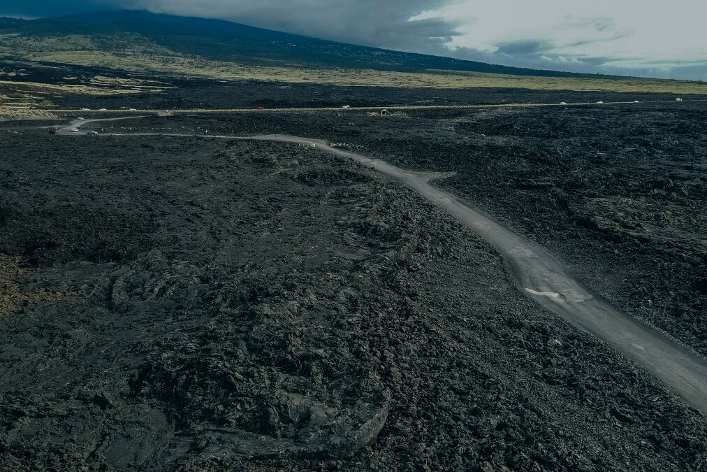 Chain of Craters Road in Hawaii Volcanoivid with blue ocean, waves and black sea cliffs. Cliffs were formed when Mauna Ulu exploded liquid lava.