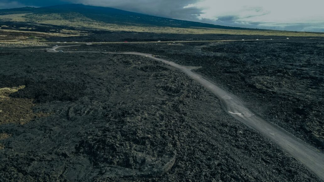 Chain of Craters Road in Hawaii Volcanoivid with blue ocean, waves and black sea cliffs. Cliffs were formed when Mauna Ulu exploded liquid lava.