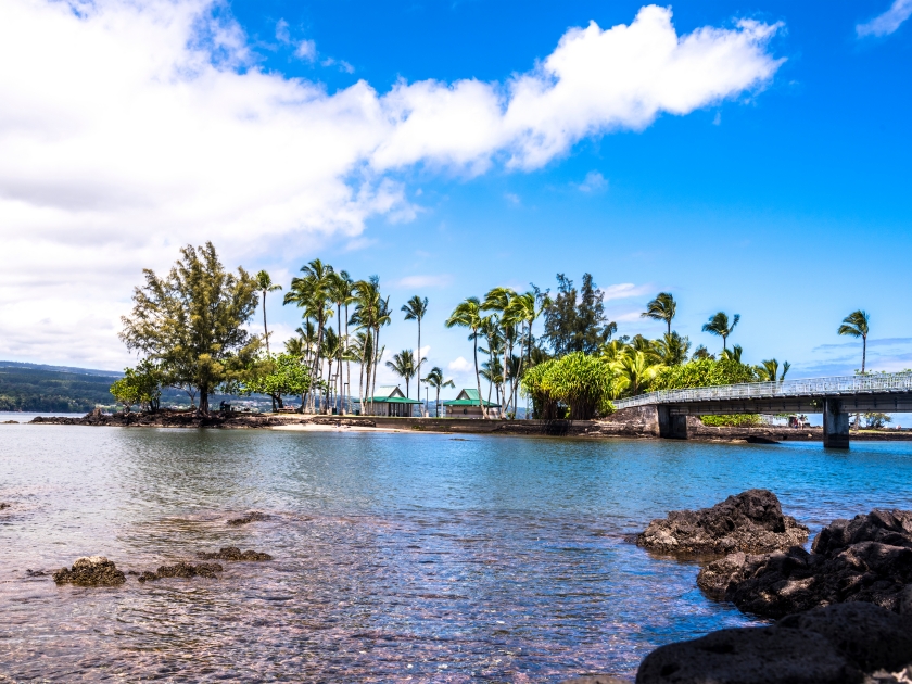 Coconut Island Hawaii depicts a calm day with gentle waves washing ashore highlighting the tropical climate and look of paradise.