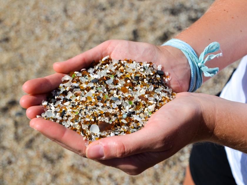 Women's hands with sand from Glass Beach in Hanapepe, Kauai, Hawaii.