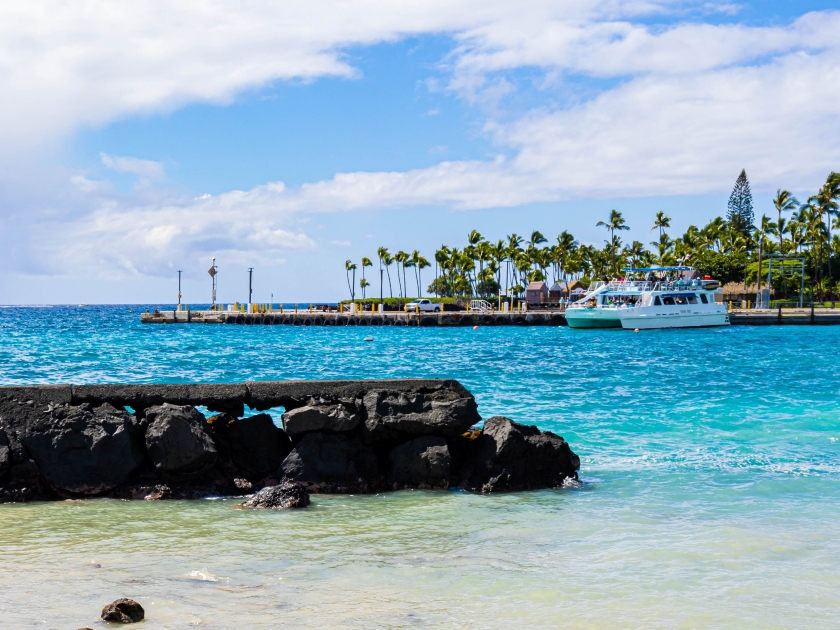 Sailboat and The Waterfront Of Kailua-Kona Across Kailua Bay, Kailua-Kona, Hawaii Island, Hawaii, USA