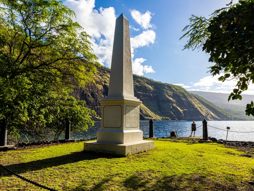 Female Hiker And Historical Captain James Cook Monument on The Shore of Kealakekua Bay, The Captain Cook Monument Trail, Captain Cook, Hawaii Island, Hawaii, USA