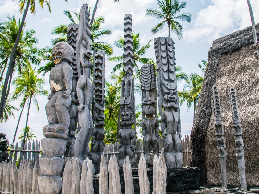 Ancient Polynesian style tiki wooden carvings greet visitors to Ki'i Pu'uhonua O Honaunau National Park on the Big Island of Hawaii.