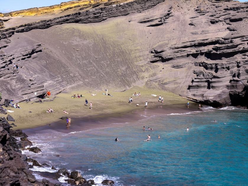 People on a Green Beach, Big Island Hawaii. Papakōlea Beach is a green sand beach located near South Point, one of four green beaches in the world.