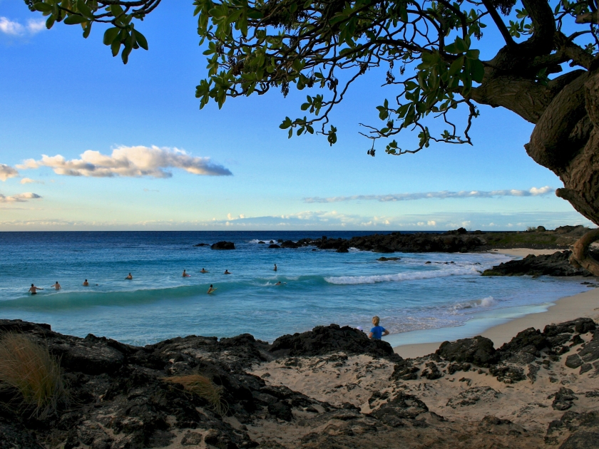 Surfers on Manini'owali beach in Hawaii