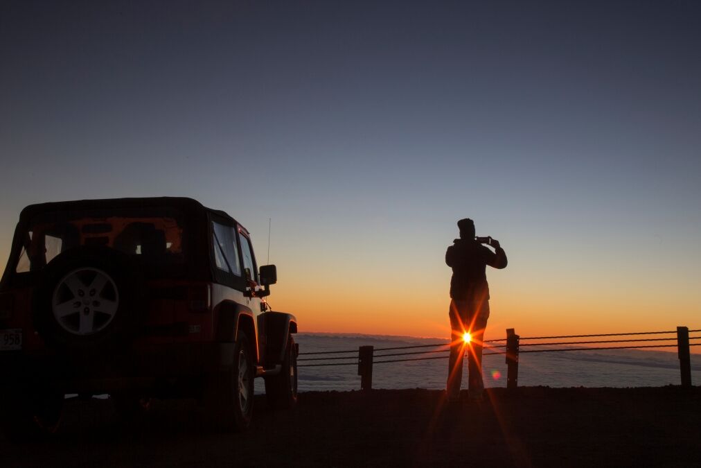 Tourist photographing sunrise at summit of Mauna Kea - Hawaii