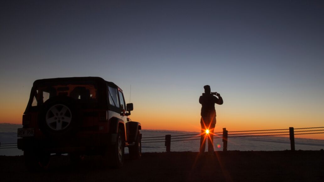 Tourist photographing sunrise at summit of Mauna Kea - Hawaii