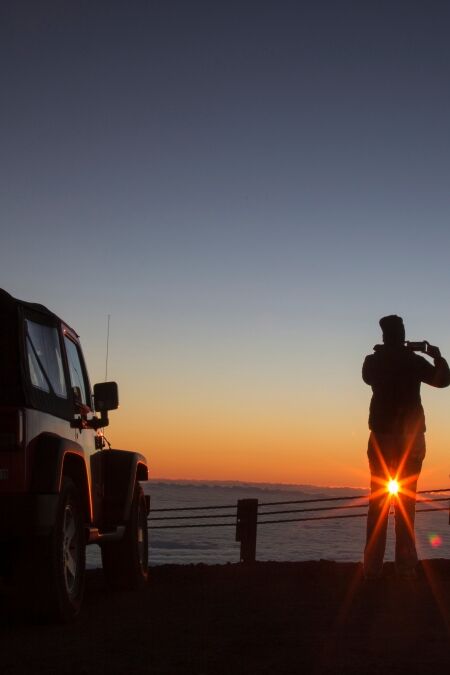 Tourist photographing sunrise at summit of Mauna Kea - Hawaii