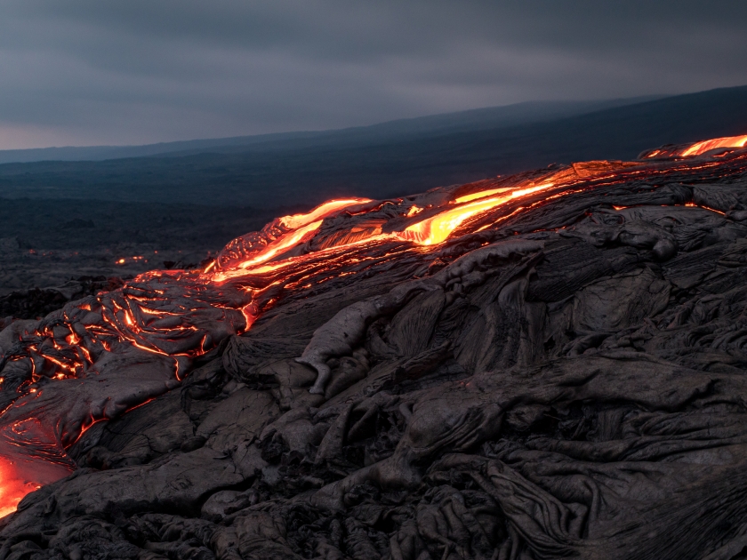 Closeup of glowing lava flow from Puu Oo in the evening on the Pali in Kalapana, Big Island, Hawaii.