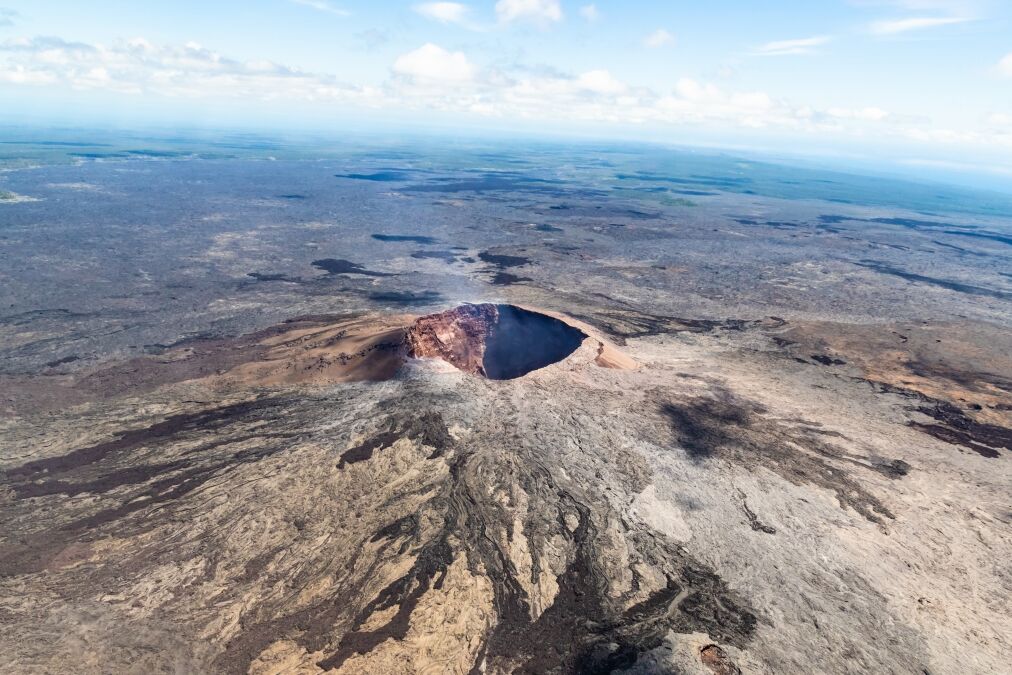 aerial view of Puu Ooo Volcanic cone on the Big Island of Hawaii. Volcanic gas can be seen escaping from the crater.