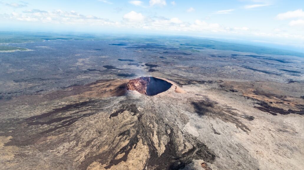 aerial view of Puu Ooo Volcanic cone on the Big Island of Hawaii. Volcanic gas can be seen escaping from the crater.