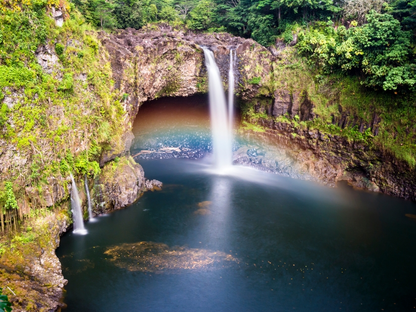 Beautiful Rainbow Falls in Hilo Hawaii forms cascading flows into a natural pool and often casts colorful rainbows when the sun position is just right, as shown here.