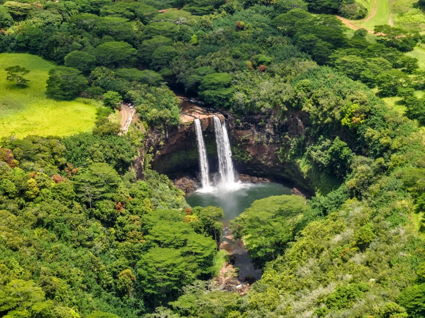 Stunning aerial view of Wailua Waterfall near the island capital Lihue on the island of Kauai, Hawaii. Wailua Falls is a 173 foot waterfall that feeds into the Wailua River. Seen from a helicopter.