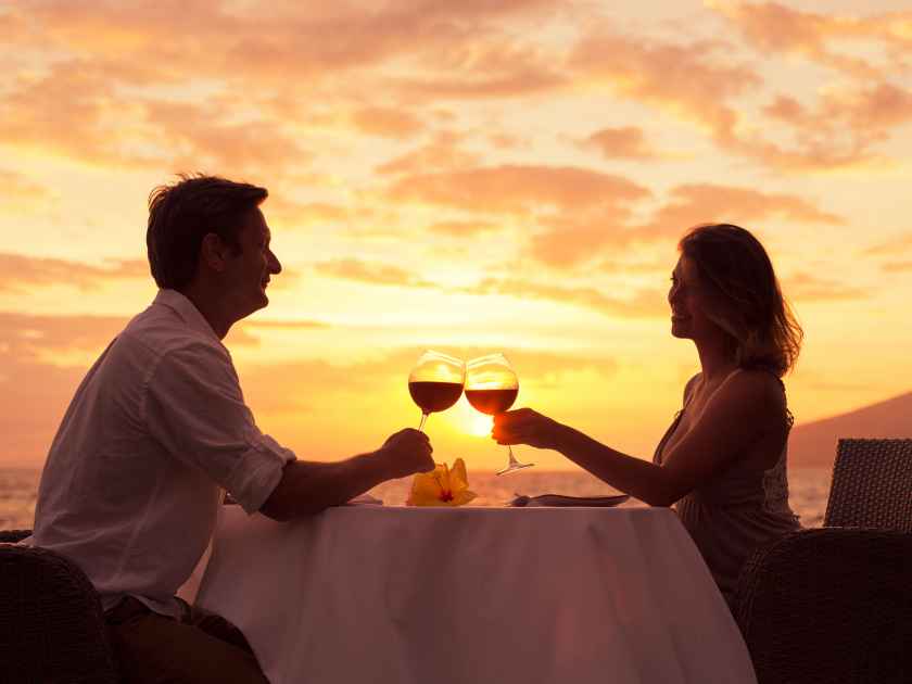 Couple sharing romantic sunset dinner on the beach