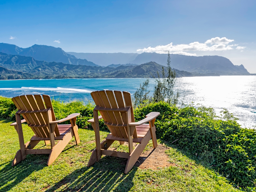 lounging chairs overlooking Hanalei Bay and the Na Pali coast Princeville Kauai Hawaii USA in the late afternoon sun