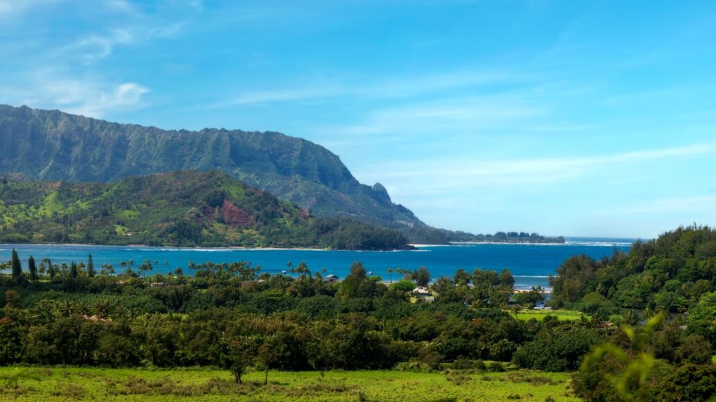 Panoramic view of Hanalei Bay, Kauai, Hawaii. The crescent-shaped Hanalei Bay is one of Hawaii’s most scenic and pleasant beaches, set beneath a range of monumental mountain peaks.