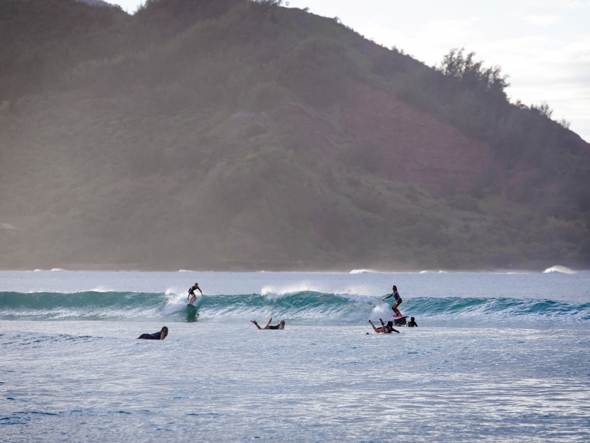 Hanalei, Hawaii US - February 22, 2024: surfers and bodyboarders in the ocean at Hanalei Bay Beach, north shore of Kauai, Hawaii. People swimming and playing in the ocean, on sunny day, Napali Coast