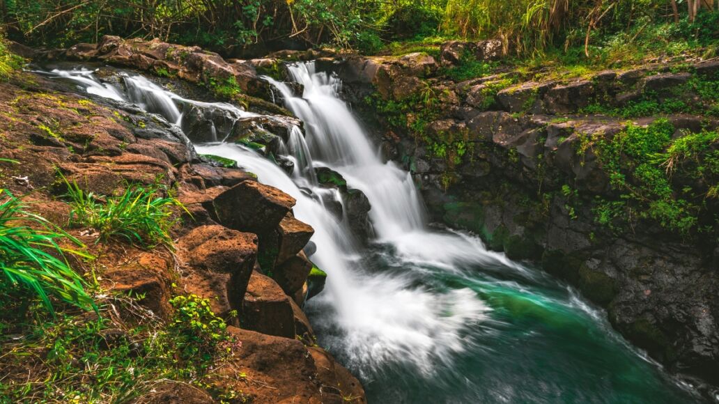 A side view of Hoʻopiʻi Falls, a series of waterfalls along the Kapaʻa Stream, located near Kapaʻa town on the island of Kauai, Hawaii, United States.