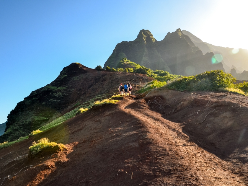 Group of young hikers at Kalalau Valley near Kalalau Beach at Na Pali Coast on the Island of Kauai, Hawaii. The only way to have this unique view from below is to hike the 11 mile long Kalalau Trail.