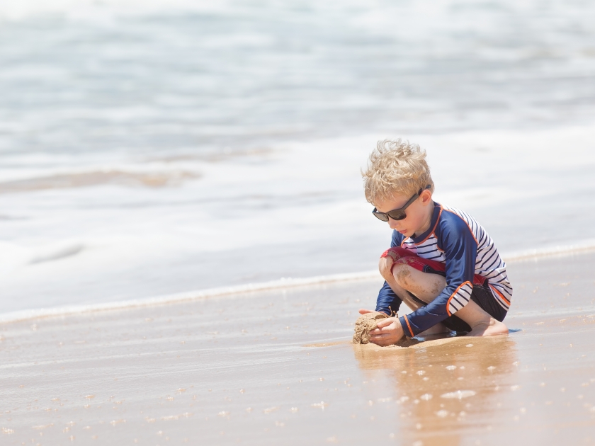 little boy playing at kealia beach at kauai island, hawaii