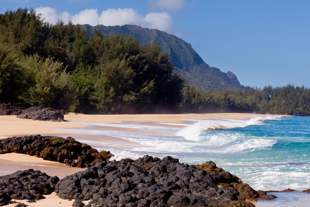 Waves crash onto Lumahai beach on Kauai Hawaii with Na Pali Coast