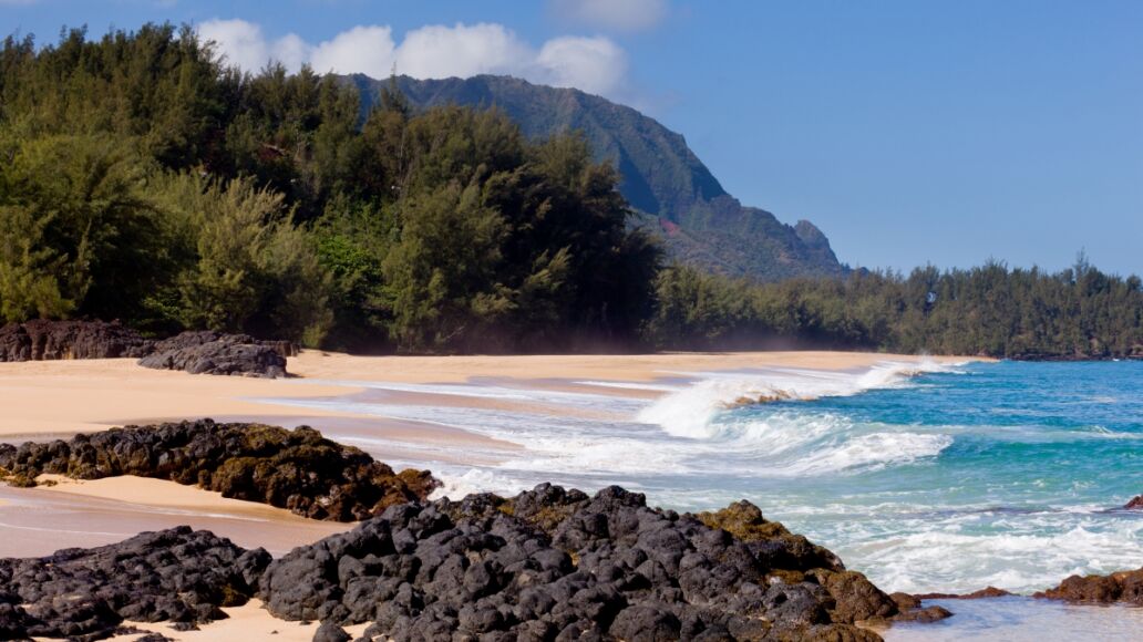 Waves crash onto Lumahai beach on Kauai Hawaii with Na Pali Coast