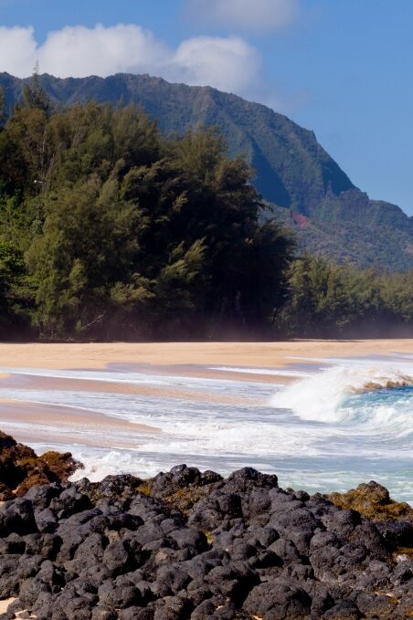 Waves crash onto Lumahai beach on Kauai Hawaii with Na Pali Coast