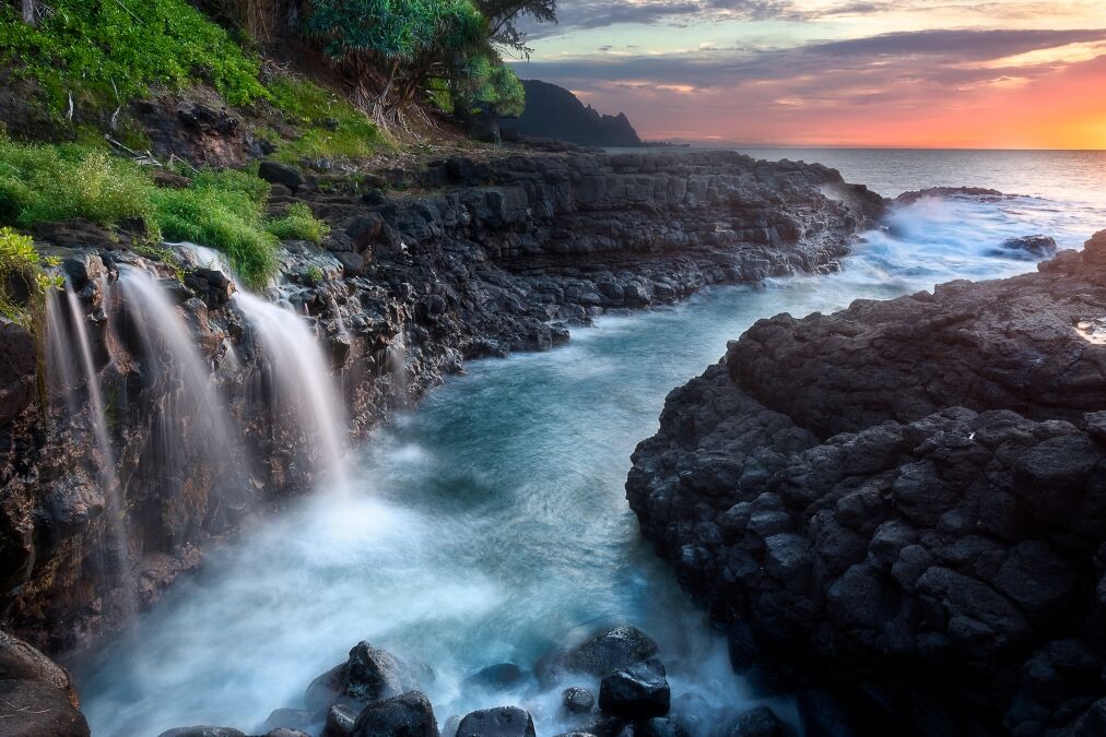 Waterfall near Queen's Bath at sunset, Kauai, Hawaii