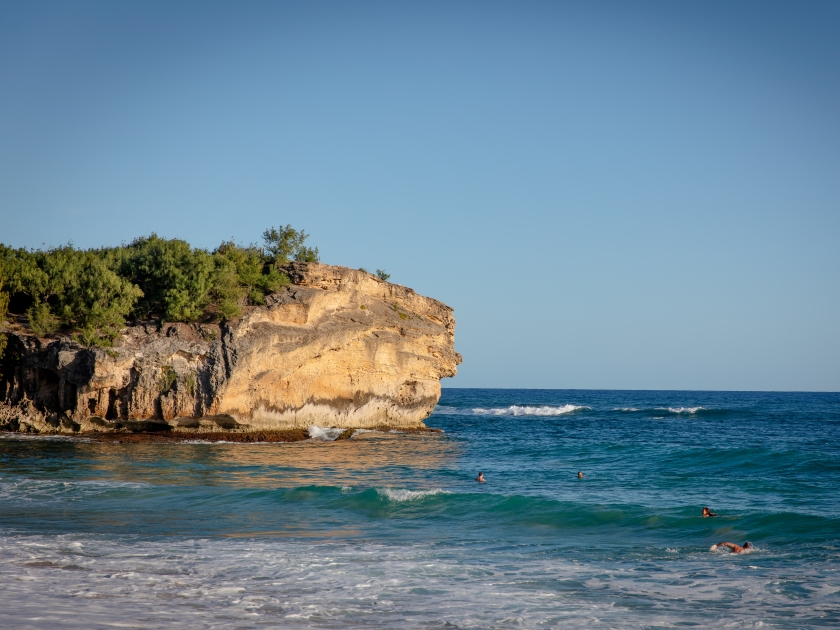 Cliff at the Shipwreck Beach on Kauai, known for surfing and sunset viewing popular spot for cliff jumping, at sunset. Beach at Grand Hyatt Kauai Resort Spa