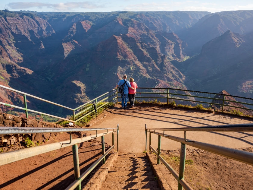 A couple enjoying the beautiful views of the Waimea Canyon lookout also known as the 