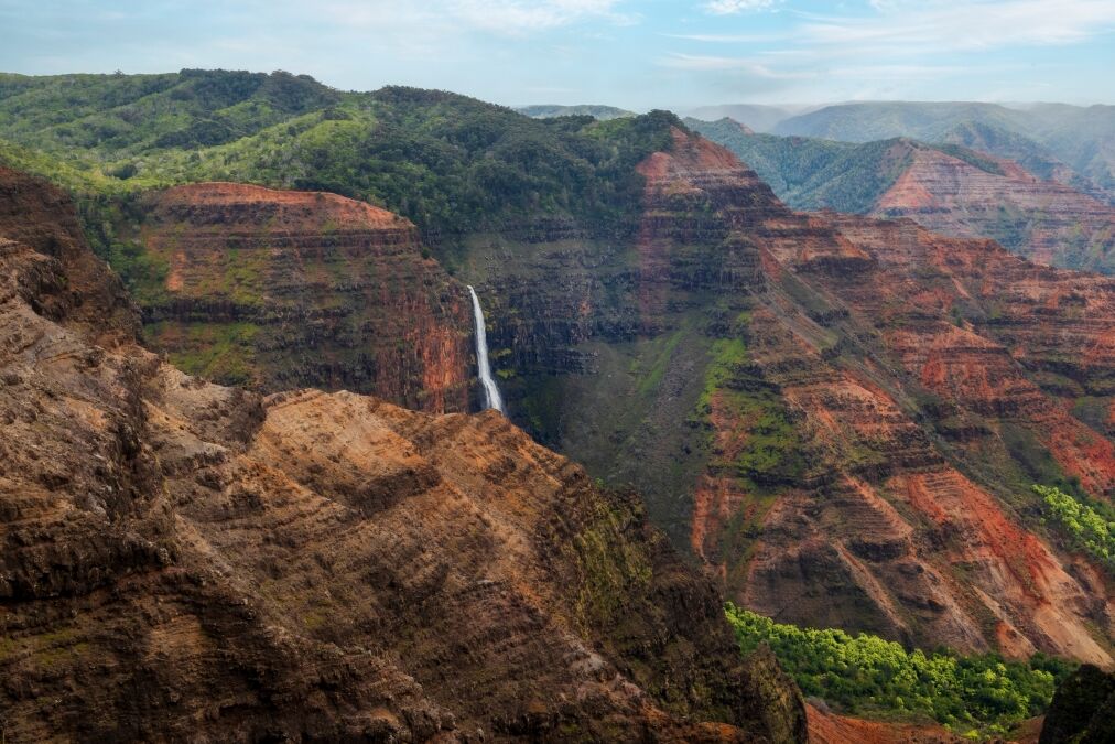 Waipo’o Falls in Waimea Canyon, Kauai, Hawaii. Waipo'o Falls, a glorious two-tier, 800 foot waterfall, cascades into the deep and colorful gorge of the Waimea Canyon below.