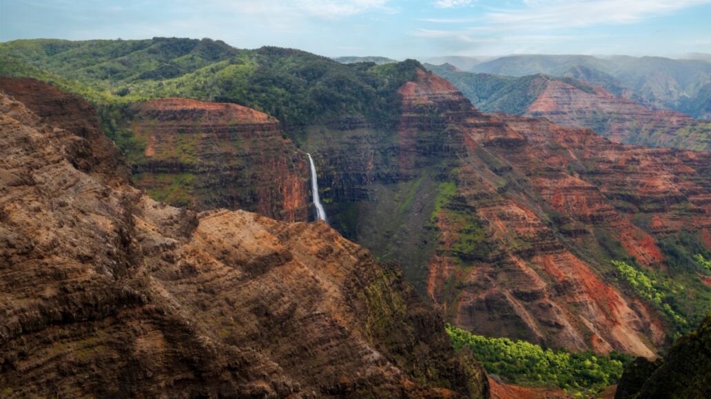 Waipo’o Falls in Waimea Canyon, Kauai, Hawaii. Waipo'o Falls, a glorious two-tier, 800 foot waterfall, cascades into the deep and colorful gorge of the Waimea Canyon below.