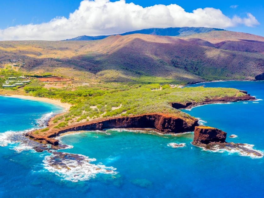 Aerial panoramic view of the island of Lanai, Hawaii, a short ferry ride from Maui, the mountains of which can be seen in the background to the right.