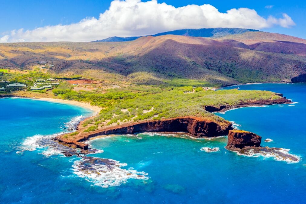 Aerial panoramic view of the island of Lanai, Hawaii, a short ferry ride from Maui, the mountains of which can be seen in the background to the right.