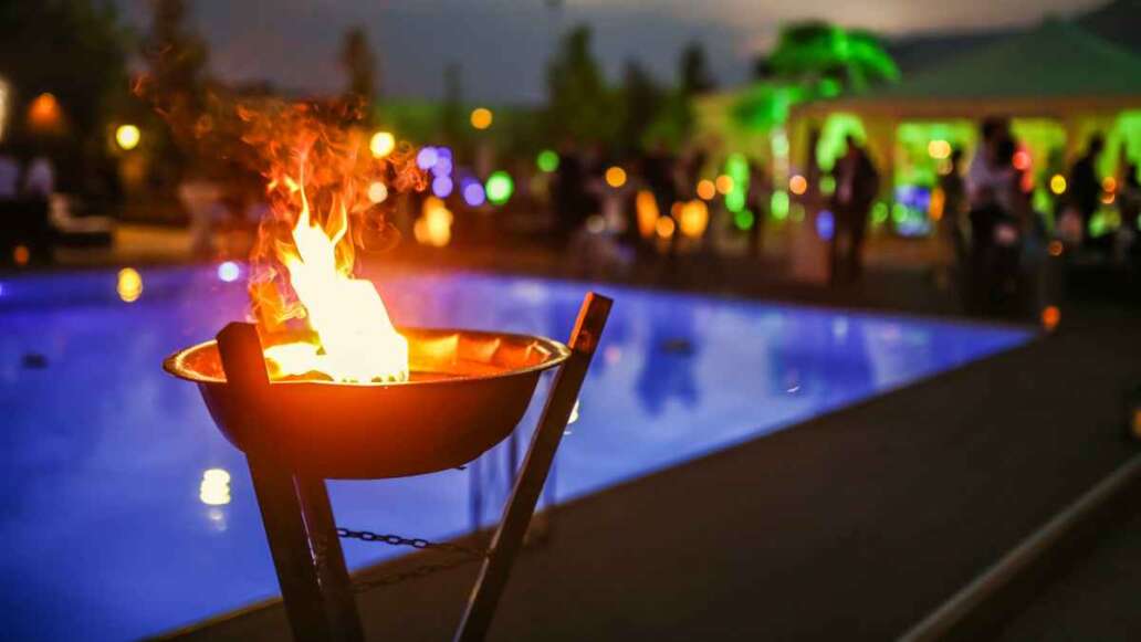 Flaming torch at sunset by the pool