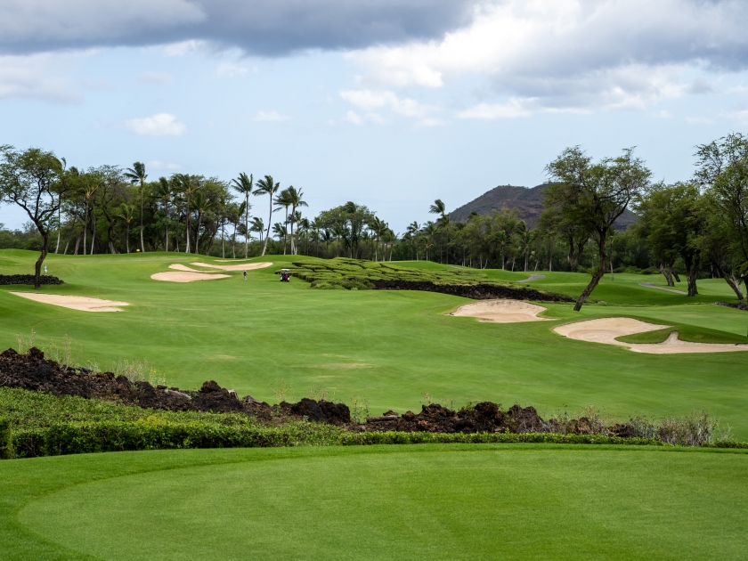 Beautiful scenic golf course from tee box to green, lava rocks, sand traps and palm trees, tropical golf vacation, Maui, Hawaii