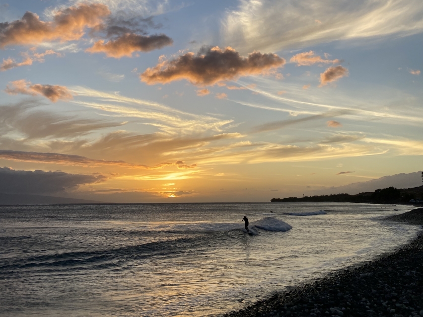 Man surfing a wave during sunset in Olowalu