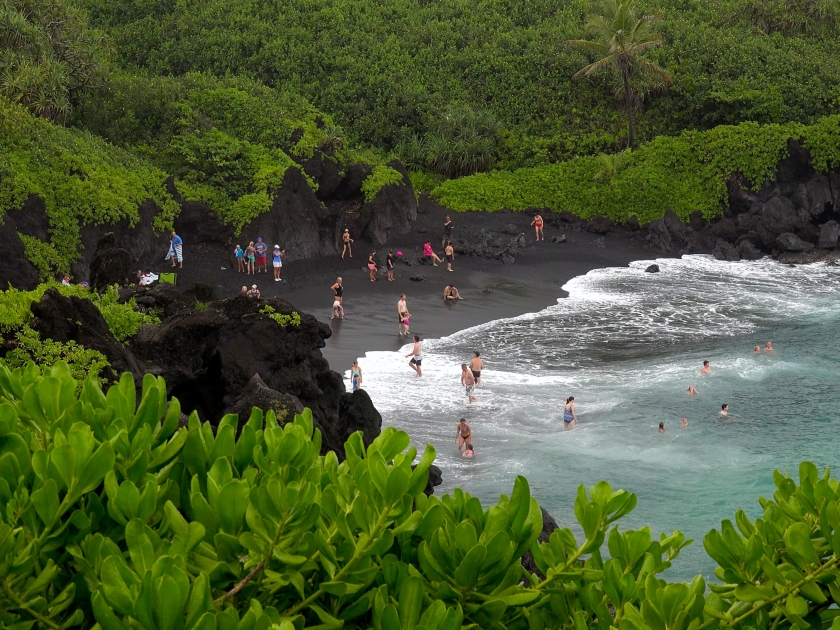 WAIANAPANAPA BEACH, HAWAII - JULY 19: Tourists visit the black sand beach at Waianapanapa Beach State Park on the island of Maui on July 19, 2015.