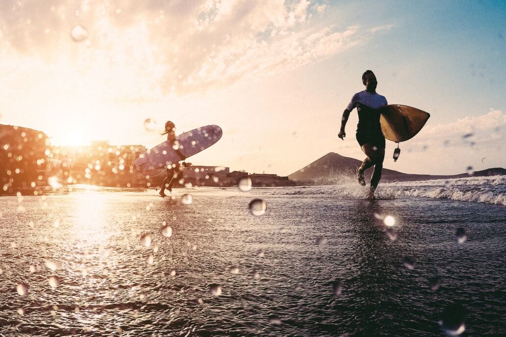 Silhouette,Of,Happy,Surfers,Running,With,Surf,Boards,On,The