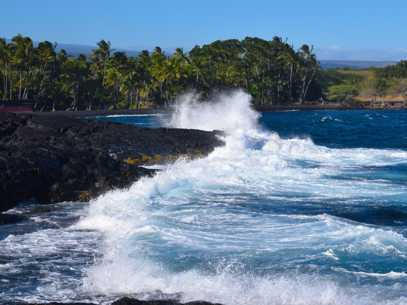 Punaluʻu Beach, big island, Hawaii. Waves crashing against volcanic rocks.