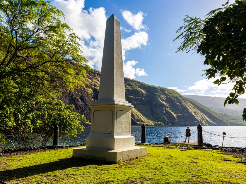 Female Hiker And Historical Captain James Cook Monument on The Shore of Kealakekua Bay, The Captain Cook Monument Trail, Captain Cook, Hawaii Island, Hawaii, USA