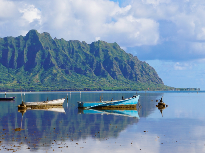 A Perfectly Still Kaneohe Bay Creates a Perfect Reflection of the Mountains and Old Boats in the Water.