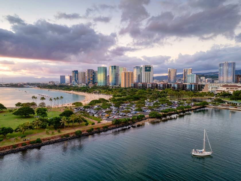 Ala Moana Beach Park and Magic Island, with Kakaako skyline of Honolulu at sunset