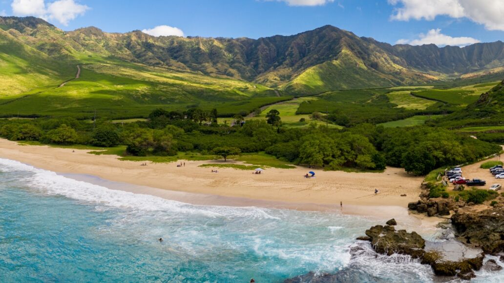 Broad panorama of Makua beach and valley from aerial view over the ocean on west coast of Oahu, Hawaii