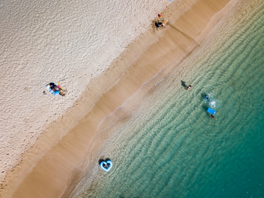 People seen from above, enjoying the tropical beach lifestyle and having fun on the landscape of the island of Oahu, Hawaii, USA.