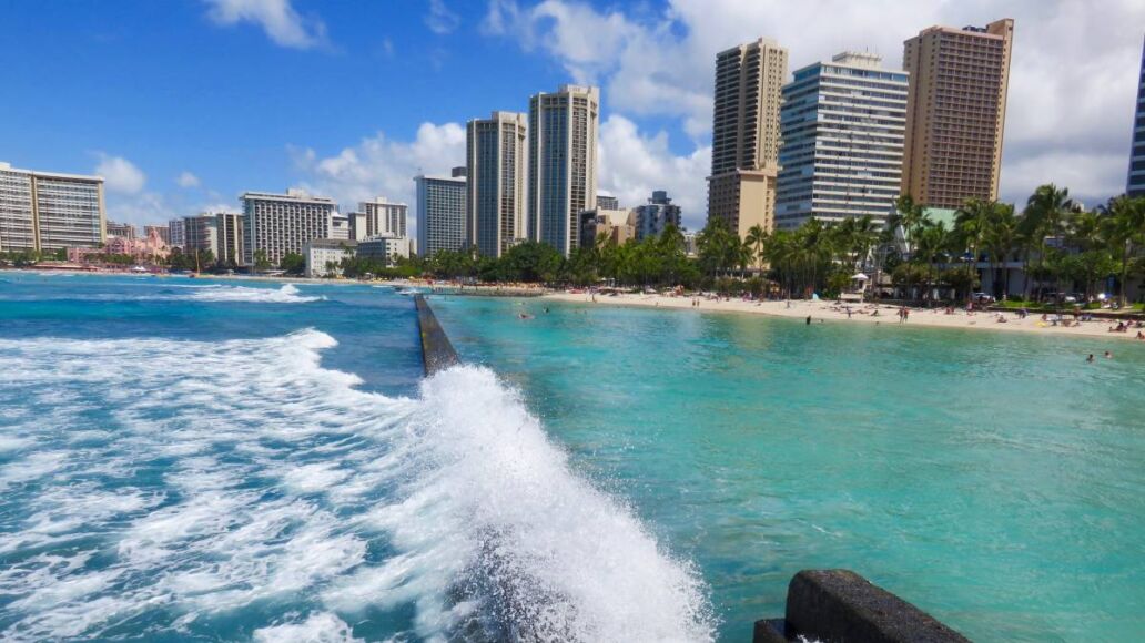 Wave Crashing on Breakwater Wall at Kuhio Beach Lagoon - View of Lagoon, Beach and Hotel Skyline - Waikiki Beach, Honolulu, Oahu, Hawaii