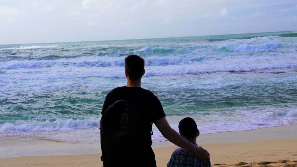 Father and son at Sunset Beach, a picturesque beach in North Shore, Oahu.