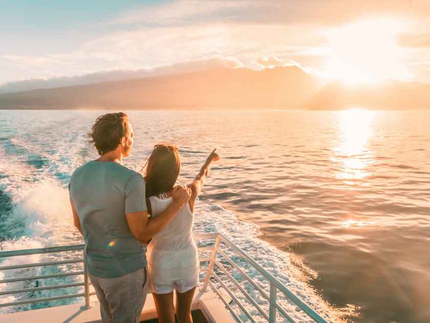 Cruise ship vacation travel tourists couple watching sunset on deck summer travel. lady pointing at sun to man tourist relaxing on Caribbean holidays.